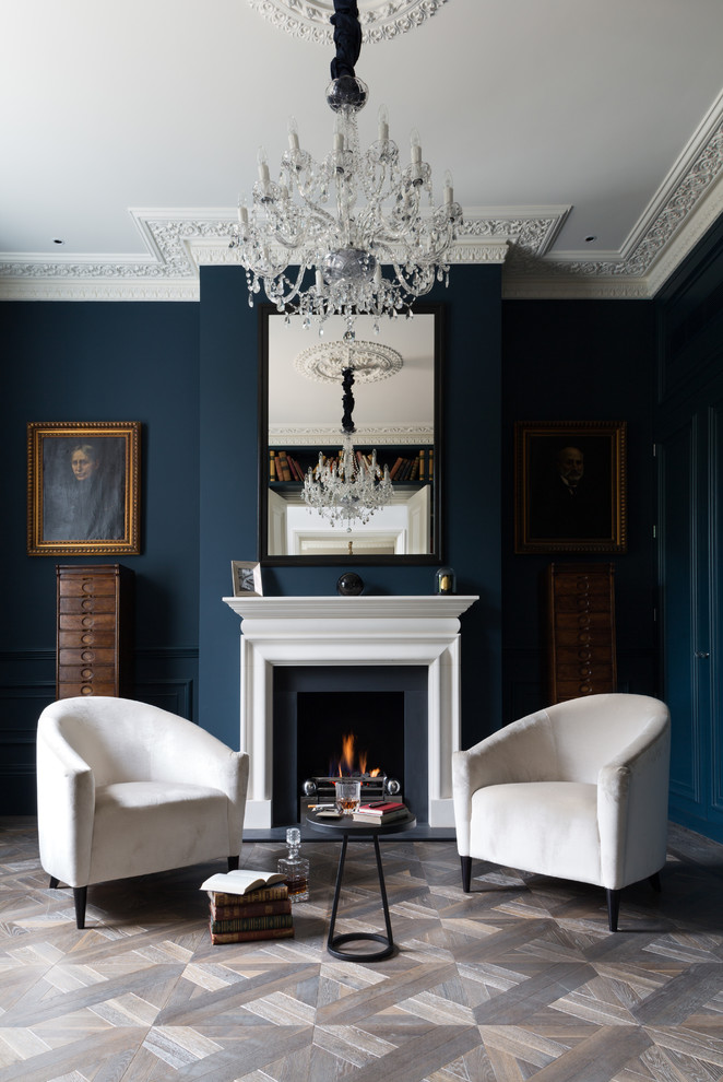 This is an example of a traditional formal enclosed living room in London with blue walls and a standard fireplace.