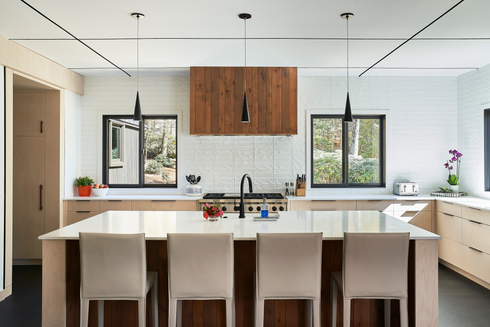 Example of a large mountain style u-shaped dark wood floor and beige floor eat-in kitchen design with flat-panel cabinets, light wood cabinets, quartzite countertops, white backsplash, ceramic backsplash, stainless steel appliances, an island and white countertops