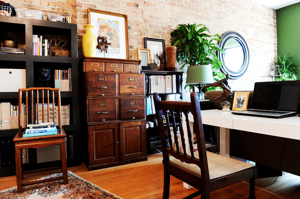Eclectic home office in Chicago with medium hardwood floors and a freestanding desk.