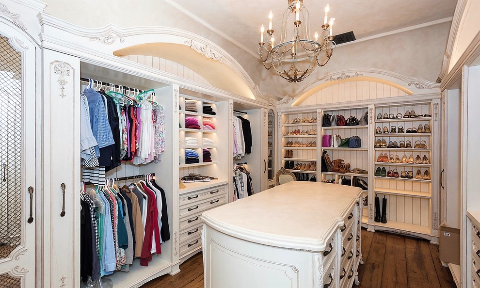 Inspiration for a large mediterranean women's walk-in wardrobe in New York with recessed-panel cabinets, beige cabinets, dark hardwood floors and white floor.