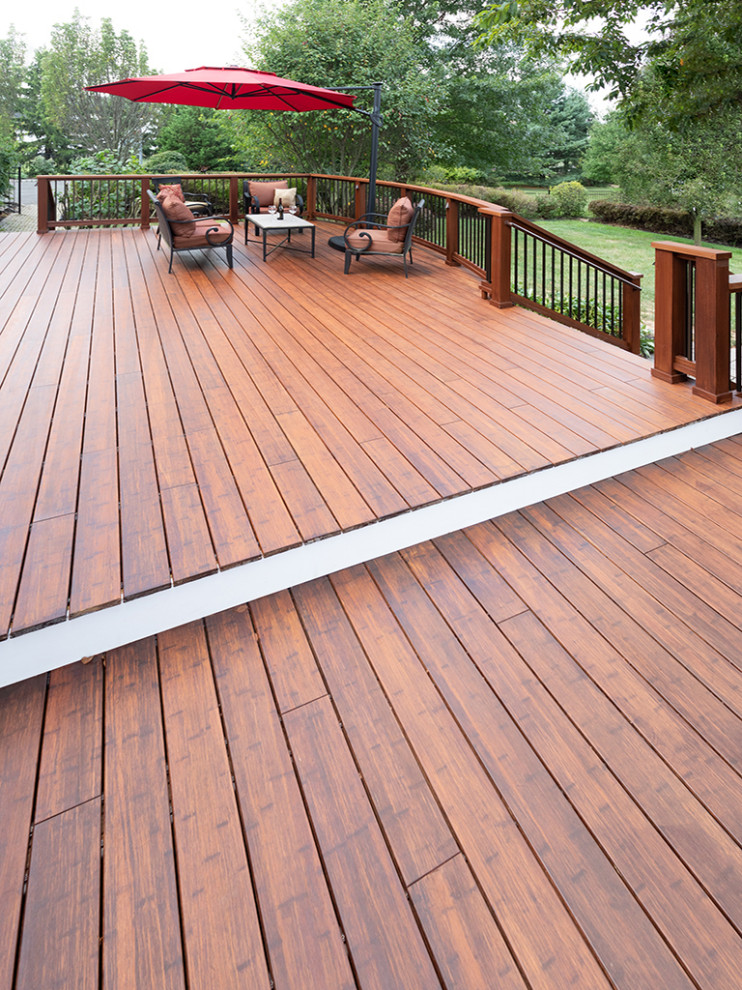 Inspiration for a large transitional backyard deck remodel with an awning