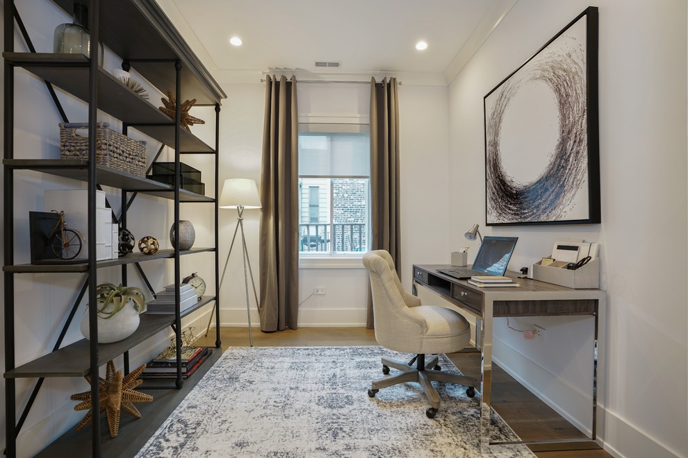 Inspiration for a transitional home office in Chicago with white walls, medium hardwood floors, a built-in desk and brown floor.