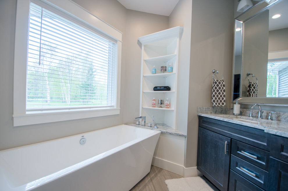 Freestanding bathtub - mid-sized transitional master freestanding bathtub idea with shaker cabinets, dark wood cabinets, gray walls, an undermount sink, marble countertops and a hinged shower door