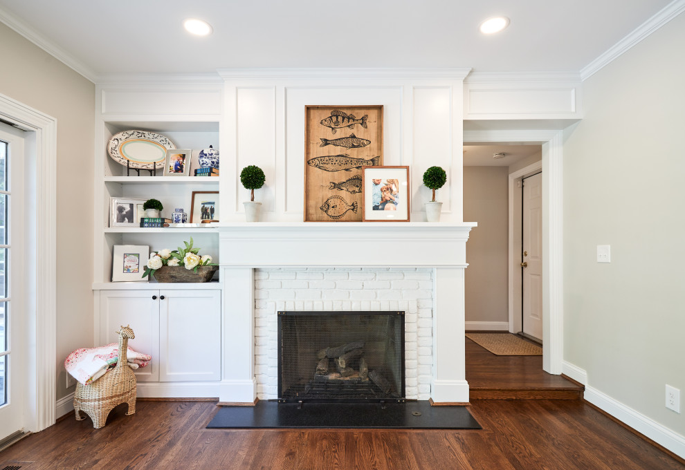 This is an example of a small traditional enclosed family room in Cincinnati with medium hardwood floors, a standard fireplace, a brick fireplace surround and brown floor.