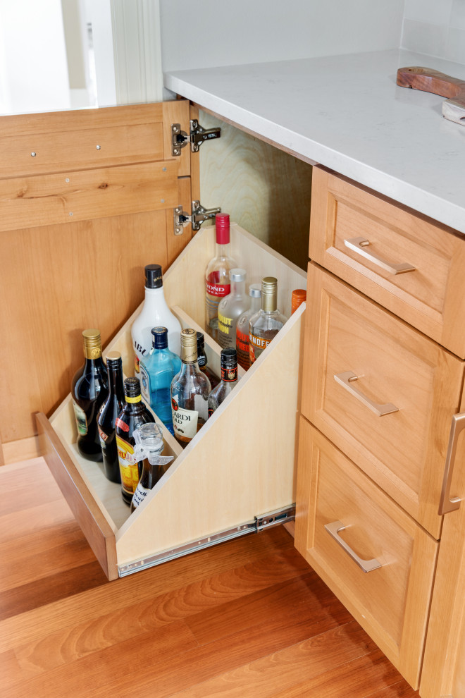This is an example of a large transitional galley wet bar in Portland with a drop-in sink, shaker cabinets, grey cabinets, quartzite benchtops, white splashback, ceramic splashback, dark hardwood floors, brown floor and blue benchtop.