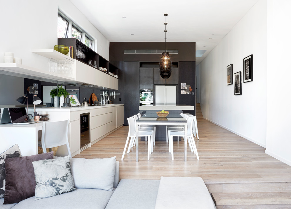 Photo of a mid-sized contemporary open plan dining in Sydney with white walls and light hardwood floors.