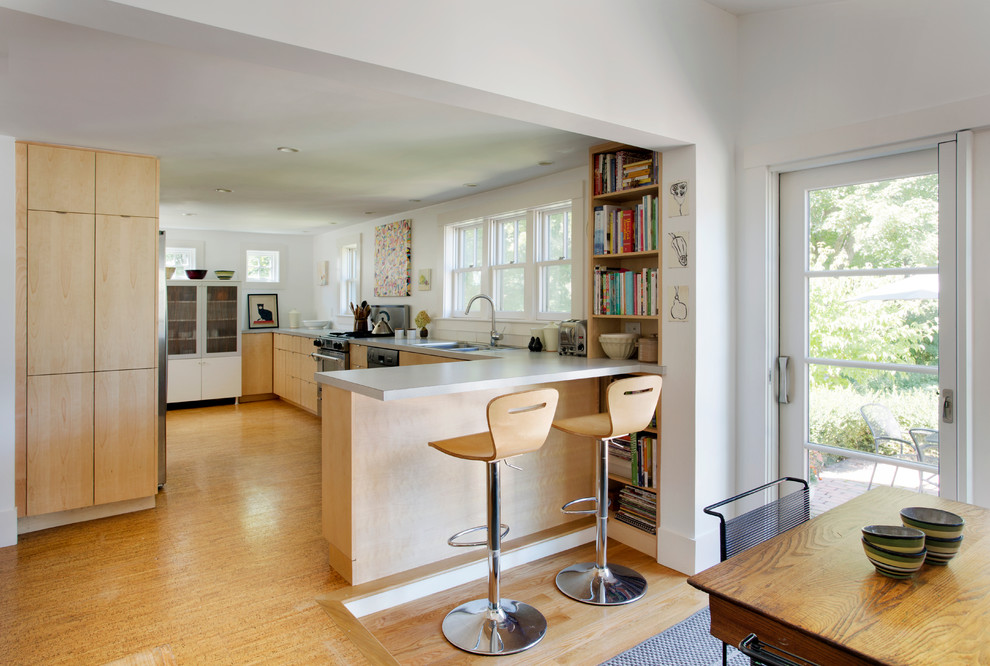 Mid-sized modern u-shaped eat-in kitchen in Boston with a double-bowl sink, flat-panel cabinets, light wood cabinets, white splashback, stainless steel appliances, laminate benchtops, bamboo floors and a peninsula.