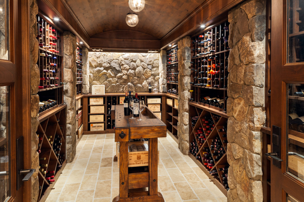 Design ideas for a large traditional wine cellar in Boston with limestone floors and diamond bins.