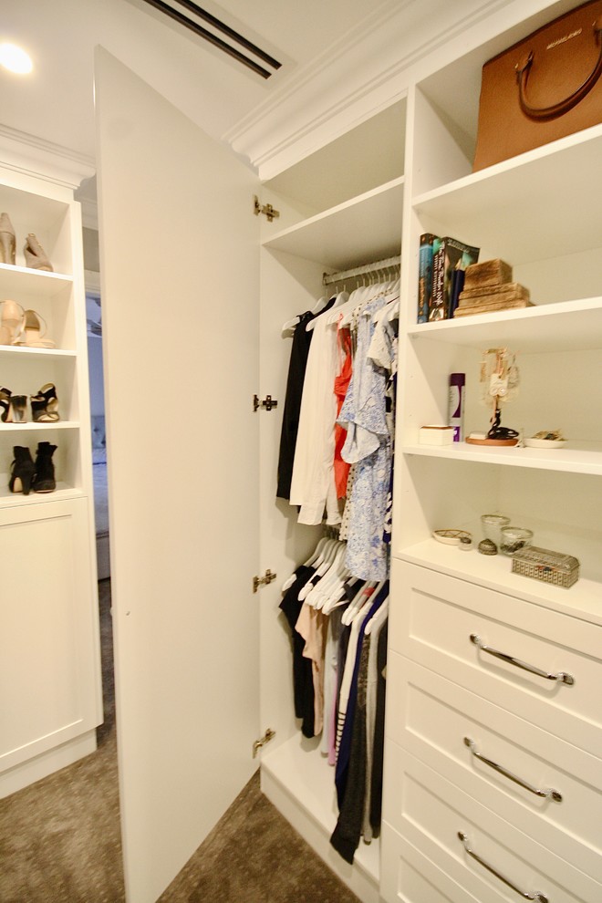 This is an example of a large transitional women's walk-in wardrobe in Sydney with recessed-panel cabinets, white cabinets, medium hardwood floors and brown floor.