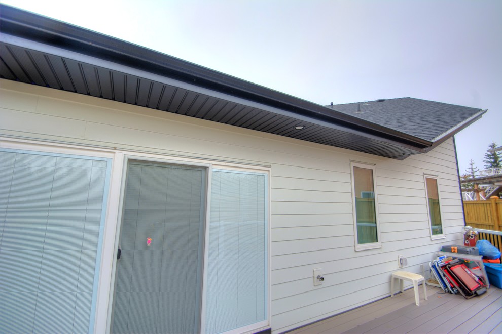 Mid-sized modern one-storey multi-coloured house exterior with mixed siding and a shingle roof.