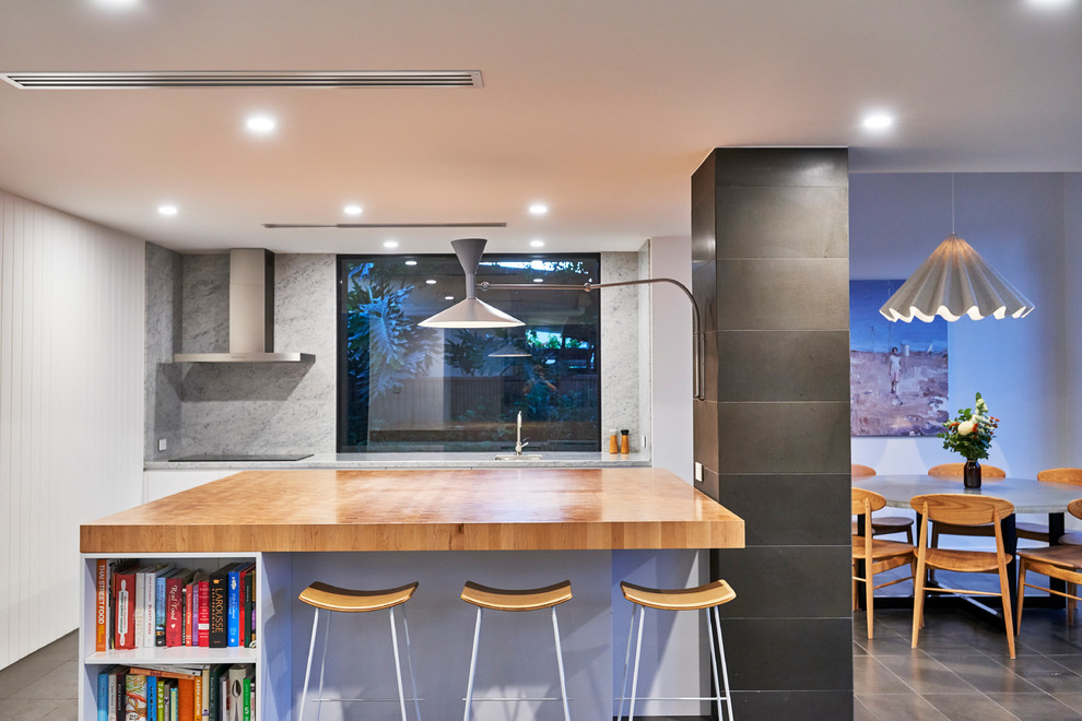 This is an example of a mid-sized contemporary single-wall eat-in kitchen in Adelaide with a single-bowl sink, beaded inset cabinets, wood benchtops, mirror splashback, with island and brown benchtop.