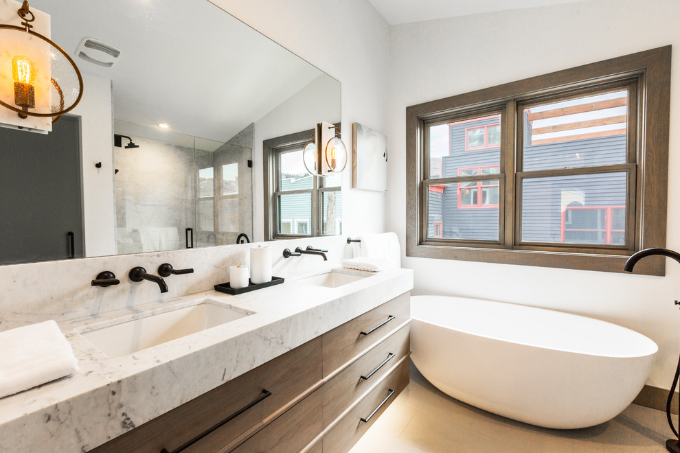 This is an example of a small contemporary master bathroom in Salt Lake City with flat-panel cabinets, light wood cabinets, a freestanding tub, an alcove shower, marble, white walls, light hardwood floors, an undermount sink, marble benchtops and a hinged shower door.