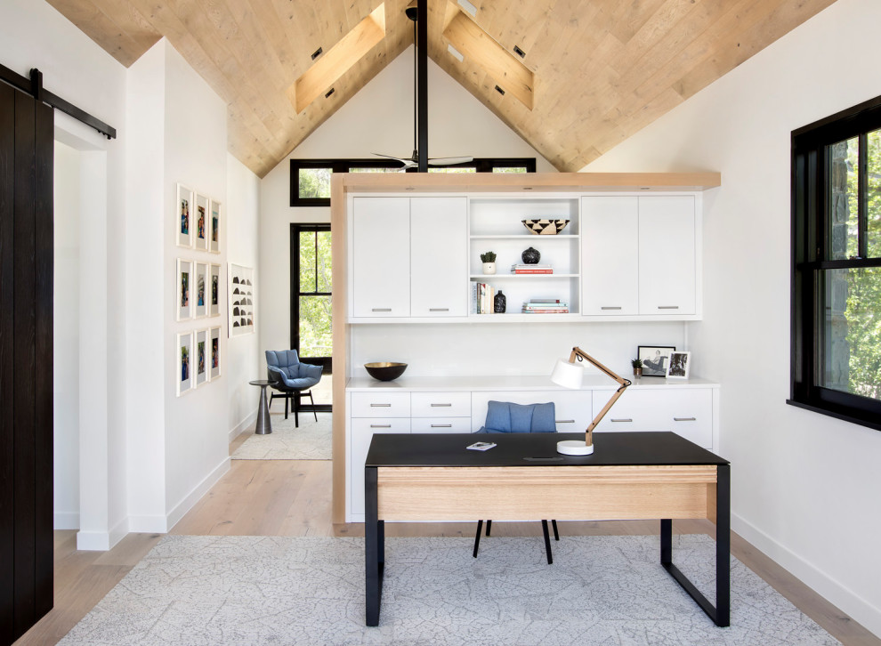 Cette photo montre un bureau tendance de taille moyenne et de type studio avec un mur blanc, un sol en bois brun, aucune cheminée et un bureau indépendant.