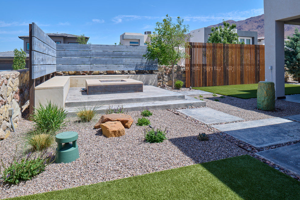 Idee per un piccolo giardino xeriscape minimal dietro casa con un focolare, pavimentazioni in cemento e recinzione in legno
