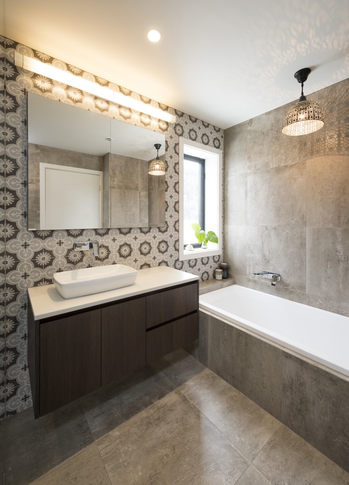Photo of a contemporary bathroom in Melbourne with a drop-in tub, porcelain tile, porcelain floors, flat-panel cabinets, dark wood cabinets, an open shower, brown tile, brown walls, a vessel sink, engineered quartz benchtops, brown floor, an open shower and brown benchtops.
