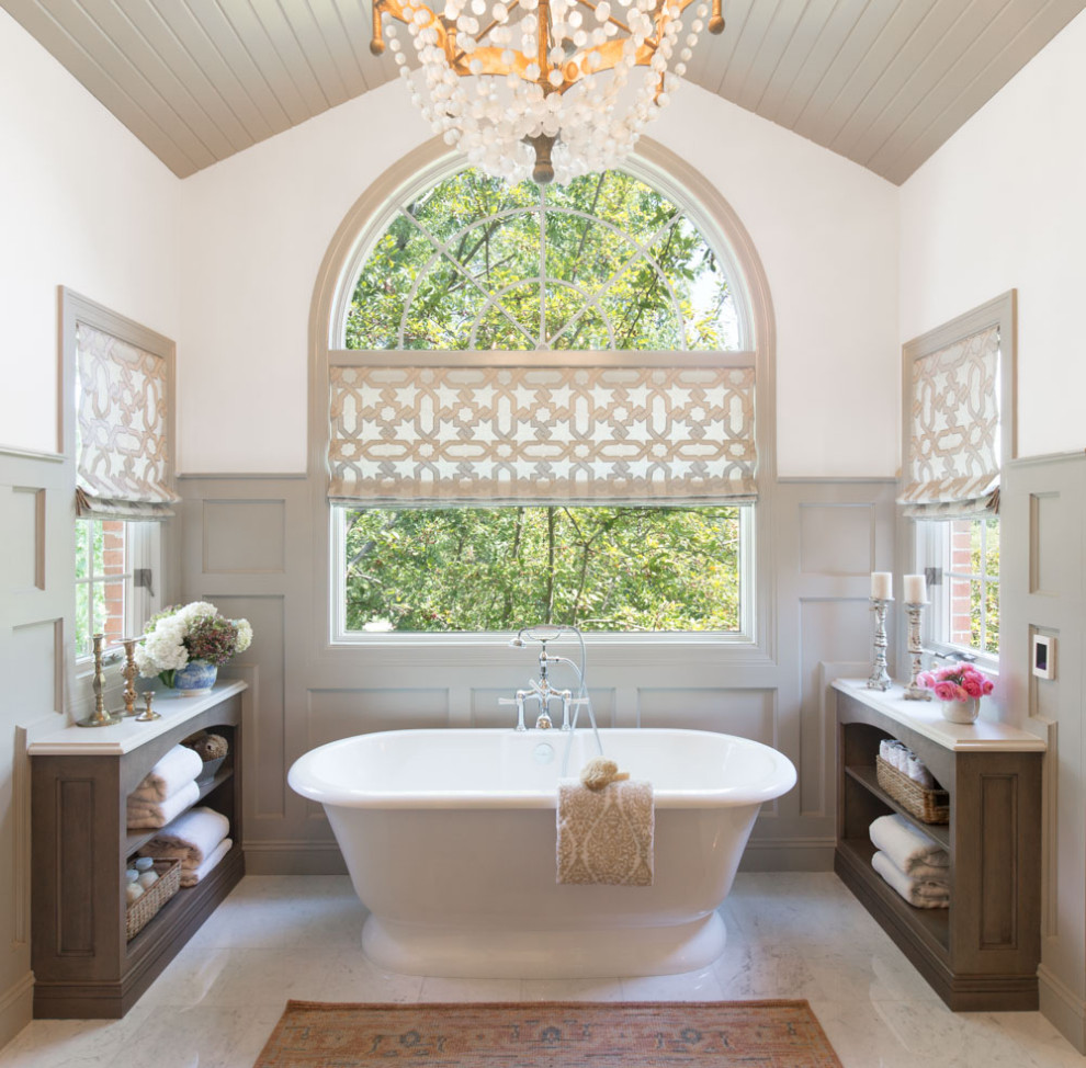 This is an example of a large transitional master wet room bathroom in St Louis with flat-panel cabinets, brown cabinets, a freestanding tub, a two-piece toilet, white tile, marble, white walls, marble floors, an undermount sink, glass benchtops, white floor, a hinged shower door and white benchtops.