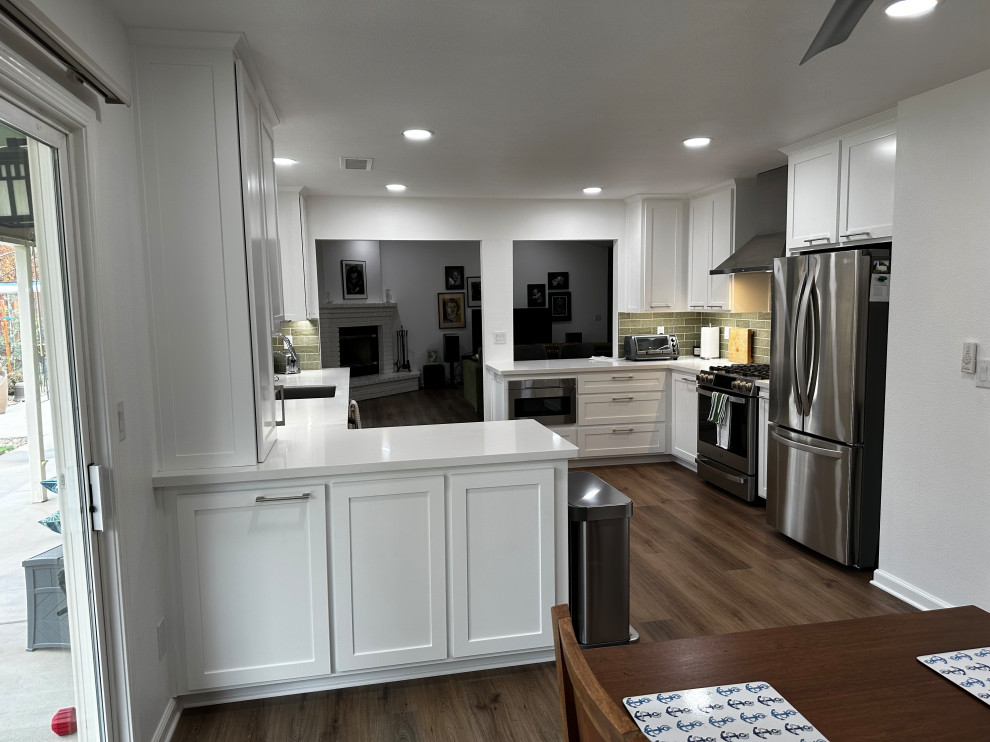Inspiration for a mid-sized transitional galley eat-in kitchen remodel in Other with a single-bowl sink, shaker cabinets, white cabinets, quartz countertops, green backsplash, subway tile backsplash, stainless steel appliances, a peninsula and white countertops