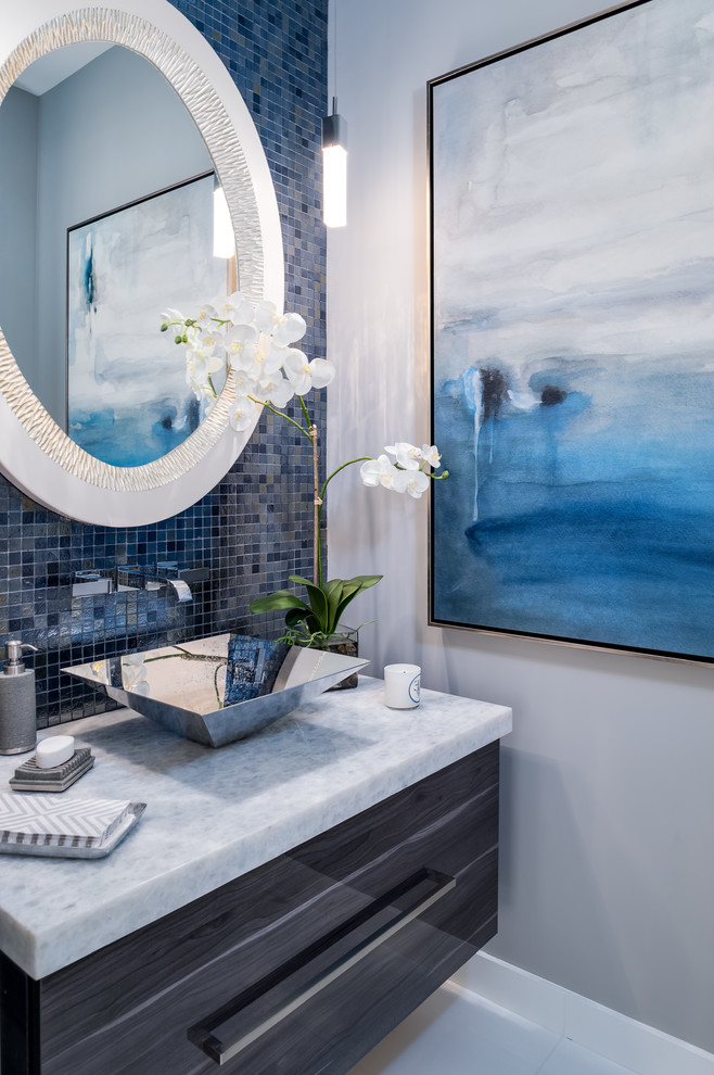 This is an example of a small transitional powder room in Miami with flat-panel cabinets, grey cabinets, blue tile, mosaic tile, white walls, a vessel sink, quartzite benchtops and white floor.
