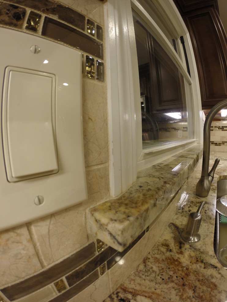 Eat-in kitchen - mid-sized contemporary l-shaped porcelain tile eat-in kitchen idea in Newark with an undermount sink, raised-panel cabinets, brown cabinets, granite countertops, beige backsplash, subway tile backsplash, stainless steel appliances and no island