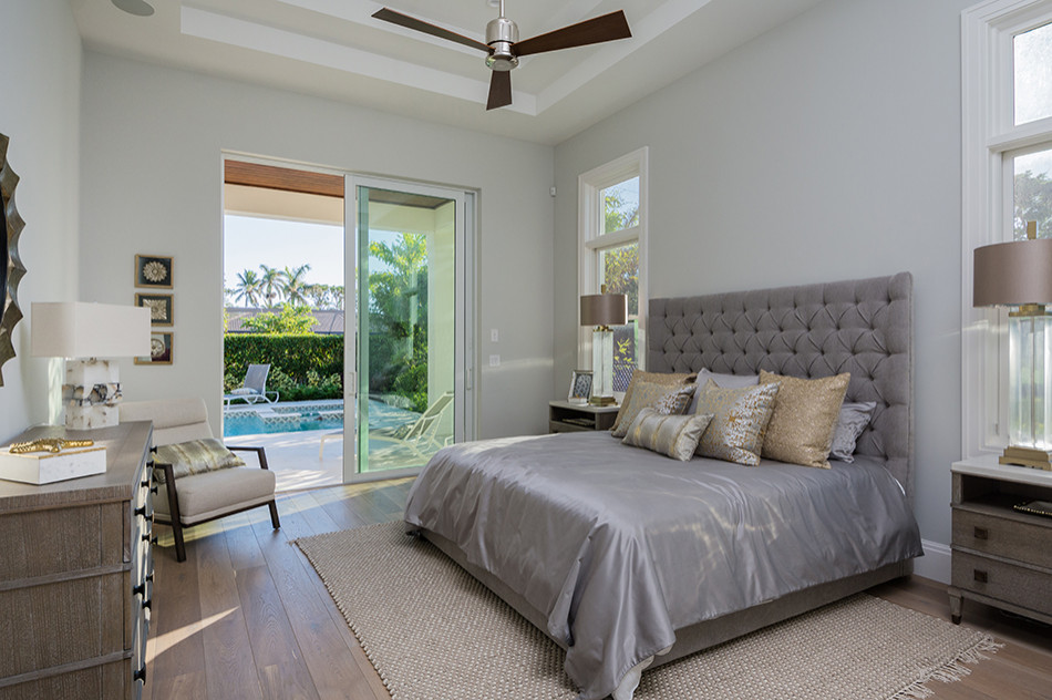 Design ideas for a mid-sized beach style master bedroom in Other with grey walls, medium hardwood floors, brown floor and coffered.
