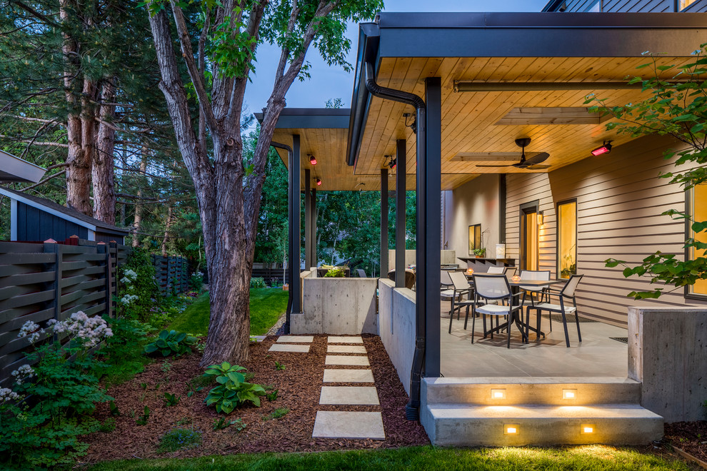 Inspiration for a mid-sized contemporary backyard concrete paver patio remodel in Denver with a roof extension