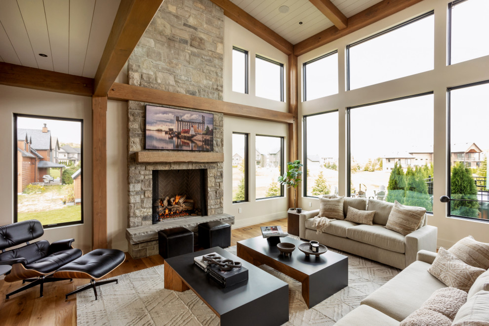 Design ideas for a country living room in Other with beige walls, medium hardwood floors, a standard fireplace, a stone fireplace surround, a wall-mounted tv, brown floor, exposed beam, timber and vaulted.