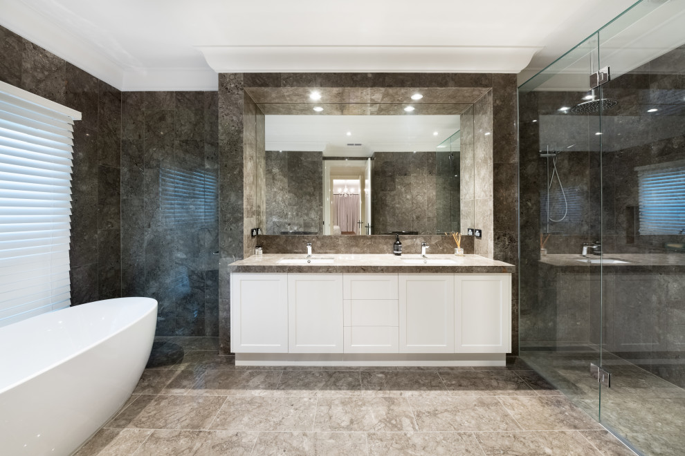 Large transitional master bathroom in Melbourne with shaker cabinets, white cabinets, a freestanding tub, a curbless shower, gray tile, an undermount sink, grey floor, a hinged shower door, grey benchtops, a double vanity and a floating vanity.