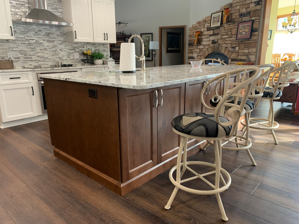 Inspiration for a mid-sized transitional l-shaped eat-in kitchen remodel with shaker cabinets, white cabinets, granite countertops, multicolored backsplash and an island