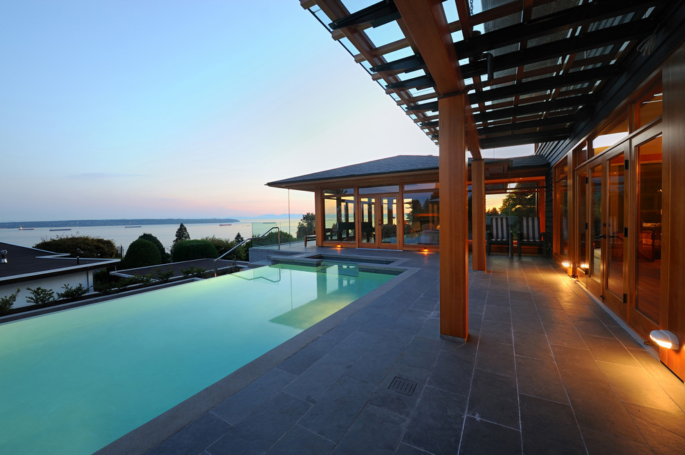 Inspiration for a large contemporary backyard rectangular infinity pool in Vancouver with a hot tub and tile.