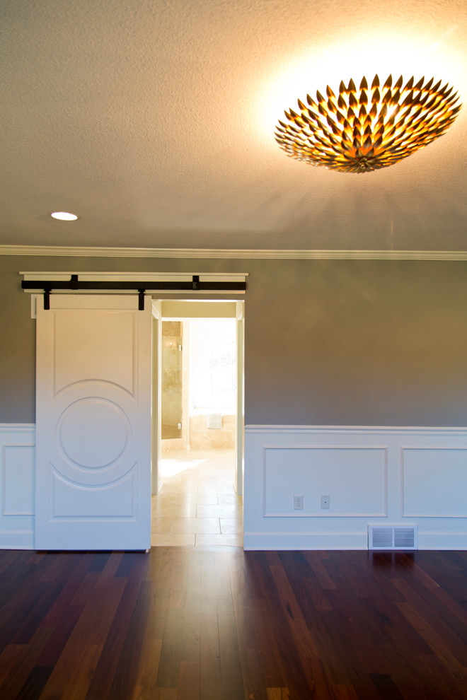 Photo of a large transitional master bedroom in Kansas City with beige walls and dark hardwood floors.