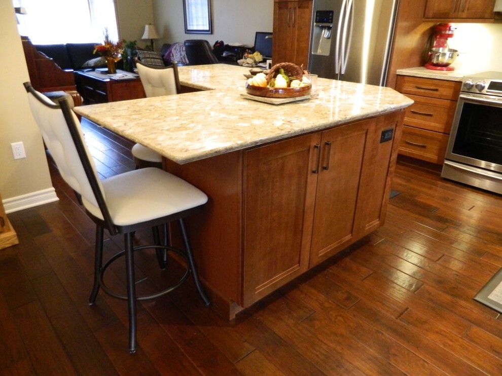 Transitional medium tone wood floor eat-in kitchen photo in Toronto with an undermount sink, recessed-panel cabinets, quartz countertops, stainless steel appliances and an island