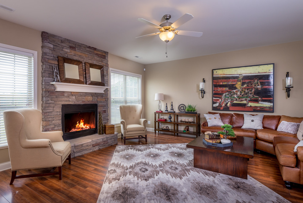 Photo of a traditional open concept living room in Other with beige walls, medium hardwood floors, a standard fireplace, a stone fireplace surround and no tv.