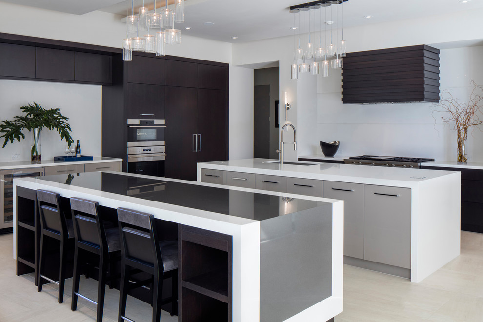 Contemporary kitchen in Orlando with flat-panel cabinets, white splashback, stainless steel appliances, multiple islands, an undermount sink, dark wood cabinets, beige floor and multi-coloured benchtop.