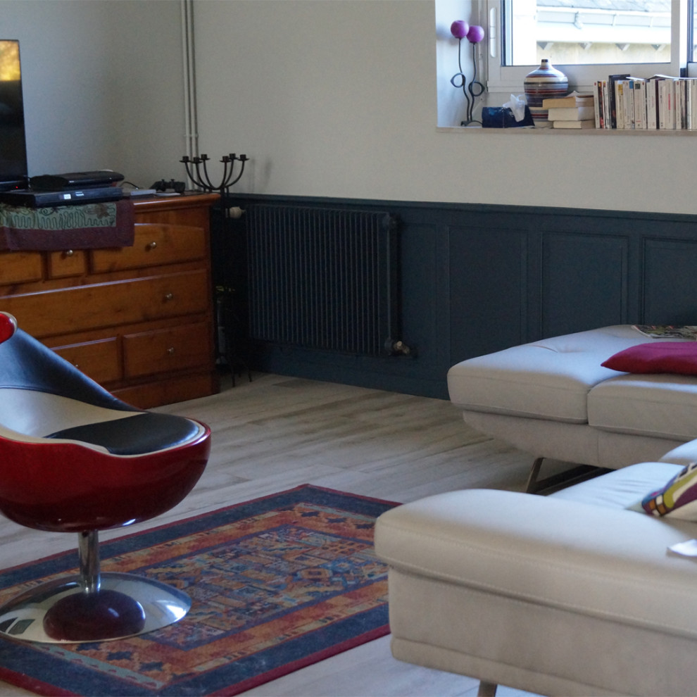 Mittelgroßes, Offenes Modernes Wohnzimmer mit blauer Wandfarbe, hellem Holzboden, freistehendem TV, grauem Boden und Holzdielendecke in Sonstige