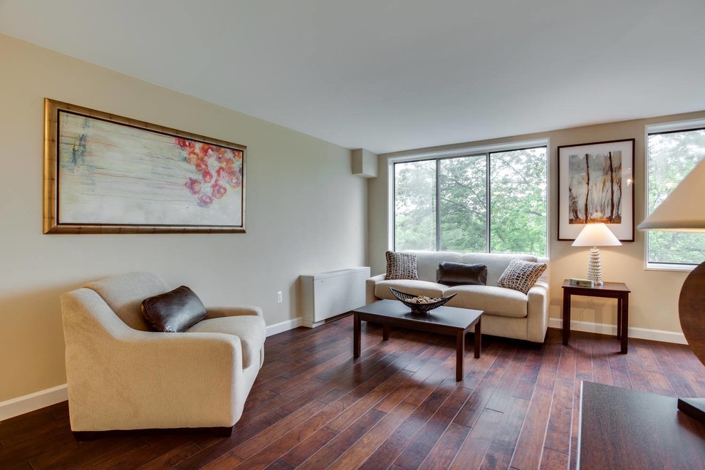 This is an example of a mid-sized transitional formal open concept living room in DC Metro with beige walls, medium hardwood floors, no fireplace, no tv and brown floor.