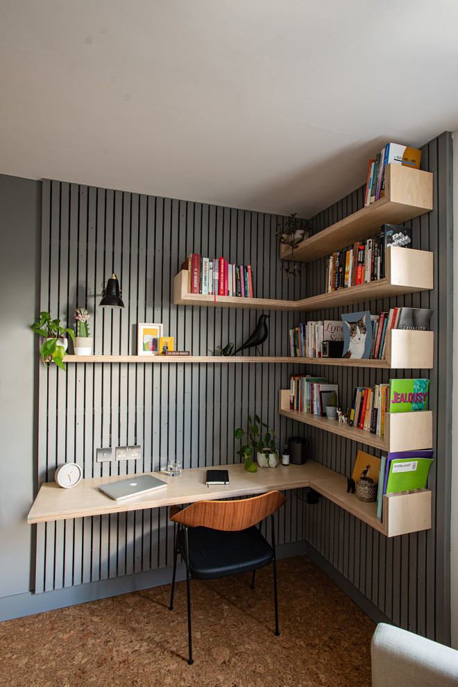 Diseño de despacho nórdico de tamaño medio con paredes grises, suelo de corcho, escritorio empotrado, suelo marrón y panelado