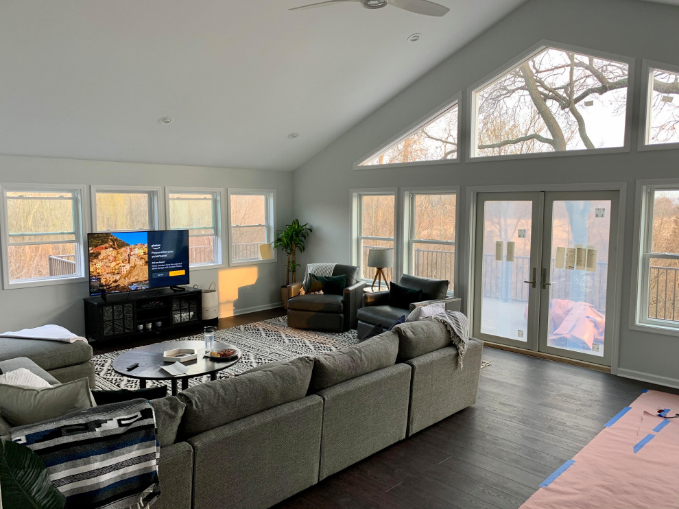 Example of a large trendy formal and open concept bamboo floor, brown floor and vaulted ceiling living room design in Detroit with white walls, no fireplace and a tv stand