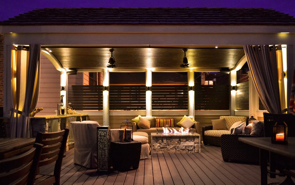 Photo of a mid-sized contemporary rooftop deck in Chicago with a fire feature and an awning.