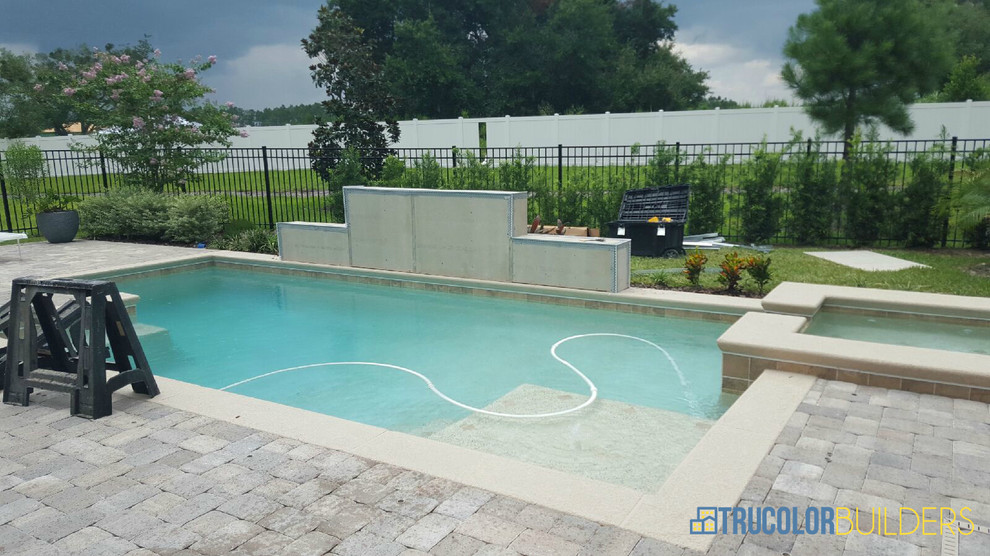 Inspiration for a mid-sized modern side yard custom-shaped aboveground pool in Orlando with a hot tub and tile.