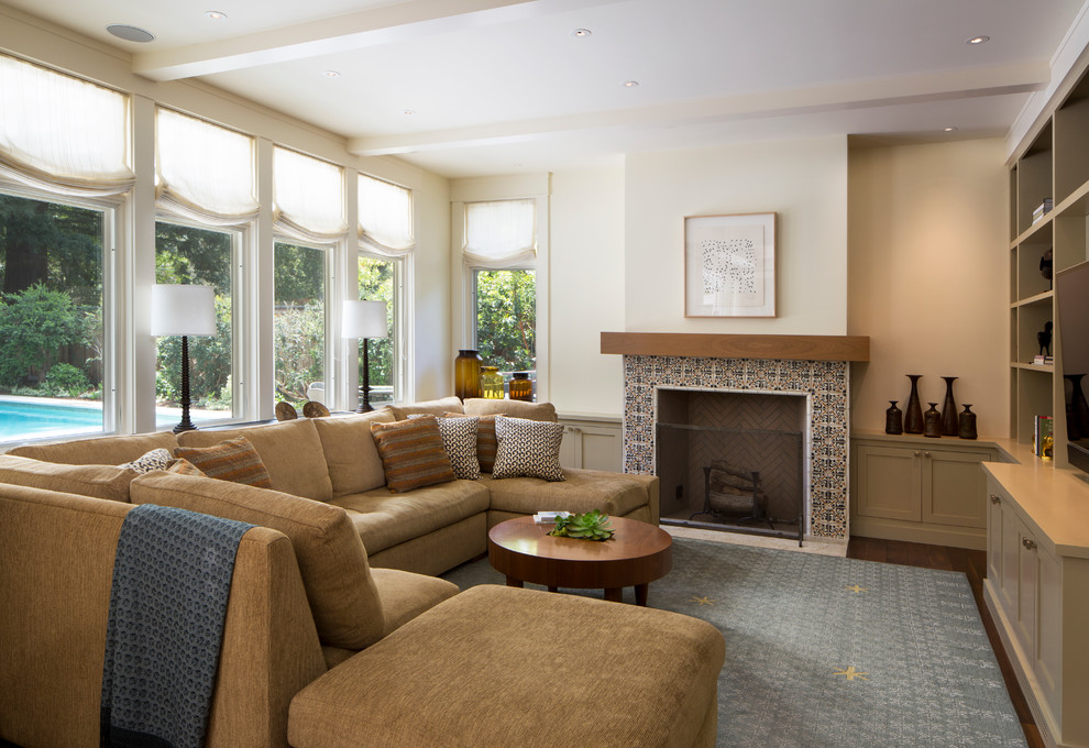 This is an example of a mid-sized traditional enclosed living room in San Francisco with beige walls, dark hardwood floors, a standard fireplace and a tile fireplace surround.