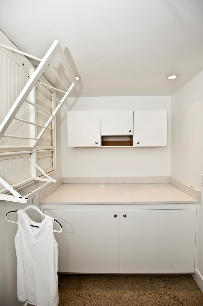 Design ideas for a large contemporary dedicated laundry room in Other with flat-panel cabinets, white cabinets, quartz benchtops, white walls, concrete floors, a side-by-side washer and dryer and grey floor.
