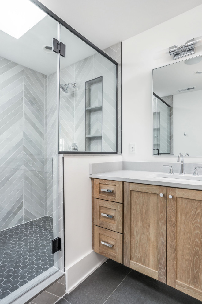 Свежая идея для дизайна: главная ванная комната среднего размера в классическом стиле с фасадами в стиле шейкер, светлыми деревянными фасадами, двойным душем, раздельным унитазом, серой плиткой, керамогранитной плиткой, белыми стенами, полом из керамогранита, врезной раковиной, столешницей из искусственного кварца, черным полом, душем с распашными дверями, серой столешницей, нишей, тумбой под две раковины и напольной тумбой - отличное фото интерьера