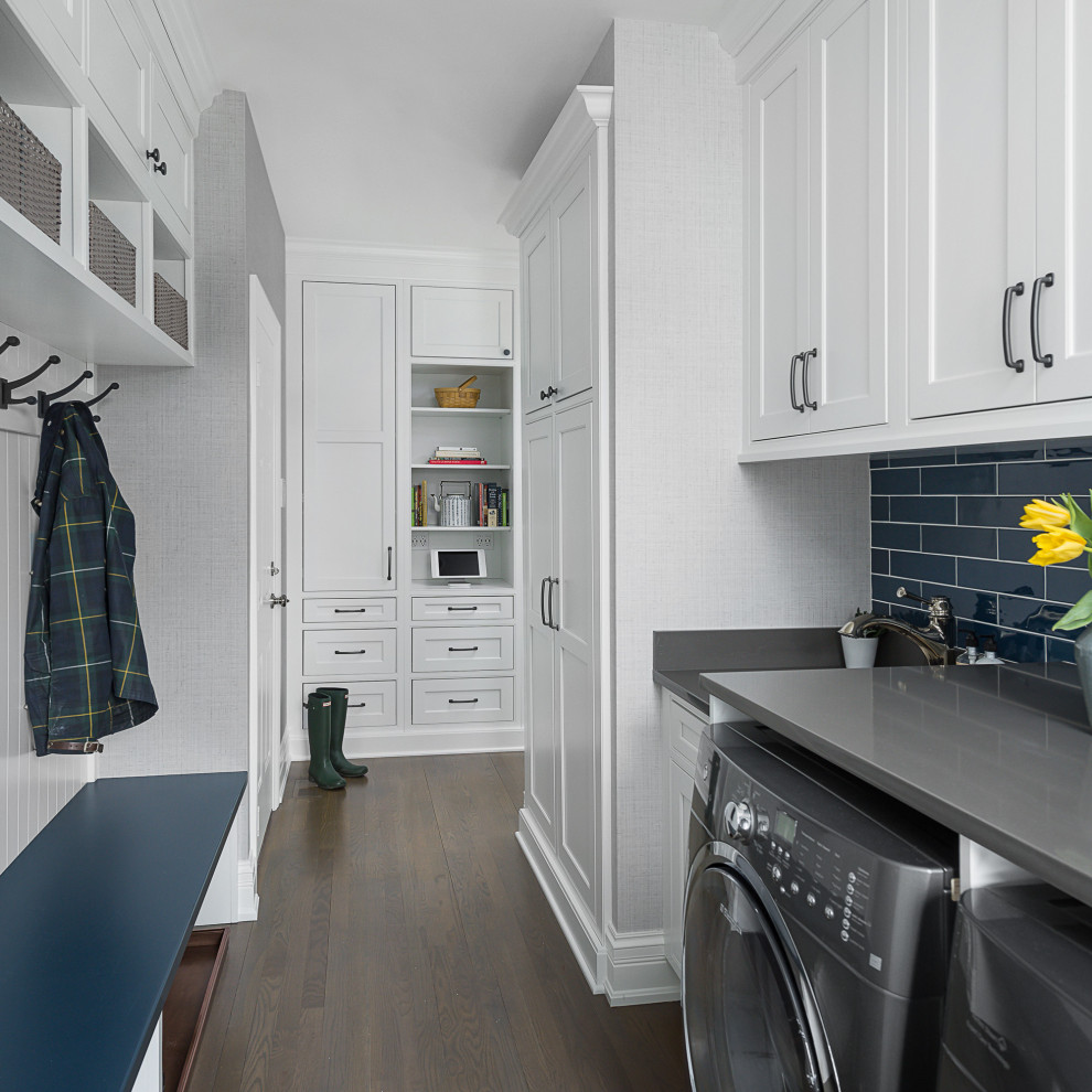 Inspiration for a mid-sized transitional galley utility room in Chicago with an undermount sink, beaded inset cabinets, white cabinets, quartz benchtops, grey walls, medium hardwood floors, a side-by-side washer and dryer, brown floor and grey benchtop.