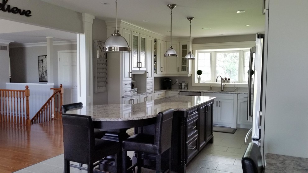 Inspiration for a large transitional u-shaped porcelain tile kitchen remodel in Toronto with an undermount sink, beaded inset cabinets, white cabinets, granite countertops, white backsplash, stainless steel appliances and an island