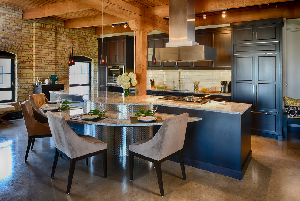 Inspiration for a mid-sized contemporary galley eat-in kitchen in Minneapolis with an undermount sink, recessed-panel cabinets, dark wood cabinets, granite benchtops, white splashback, ceramic splashback, panelled appliances, concrete floors and with island.