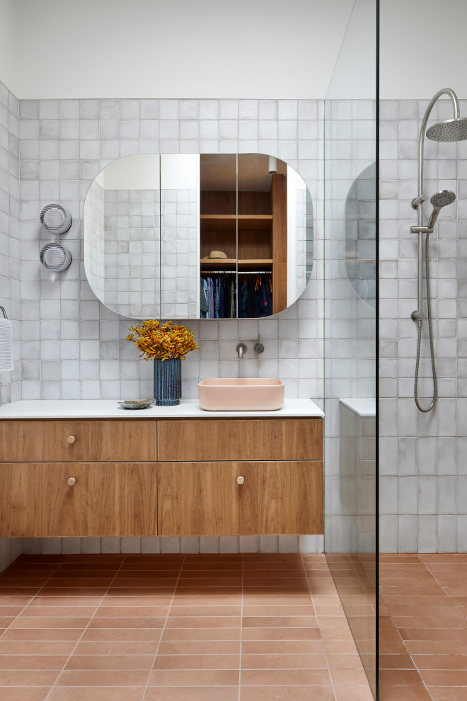 Inspiration for a mid-sized contemporary master bathroom in Melbourne with flat-panel cabinets, gray tile, ceramic tile, white walls, terra-cotta floors, a vessel sink, solid surface benchtops, an open shower, white benchtops, a single vanity, medium wood cabinets, a curbless shower, red floor and a floating vanity.