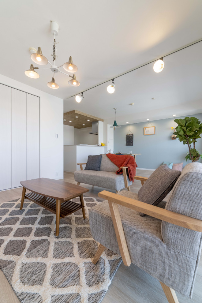 Esempio di un piccolo soggiorno scandinavo aperto con pareti bianche, pavimento in legno verniciato, TV autoportante, pavimento beige, soffitto in carta da parati e carta da parati