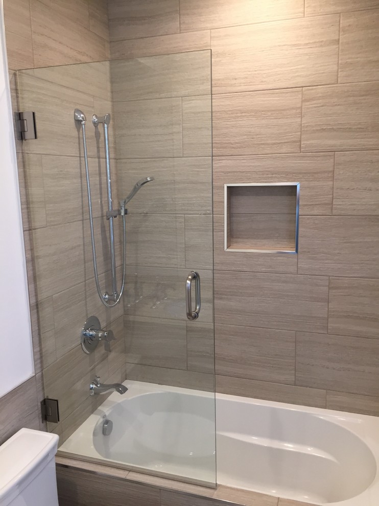 Large contemporary 3/4 bathroom in Los Angeles with flat-panel cabinets, white cabinets, a drop-in tub, a two-piece toilet, ceramic floors, an undermount sink, solid surface benchtops, grey floor, a hinged shower door, a shower/bathtub combo, brown tile, ceramic tile and beige walls.
