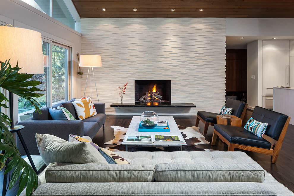 Contemporary living room in Portland with white walls, dark hardwood floors and a standard fireplace.