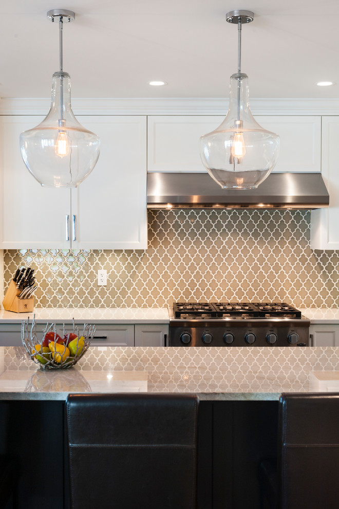 Example of a mid-sized transitional l-shaped medium tone wood floor open concept kitchen design in Vancouver with an undermount sink, shaker cabinets, white cabinets, quartz countertops, green backsplash, glass tile backsplash, stainless steel appliances and an island